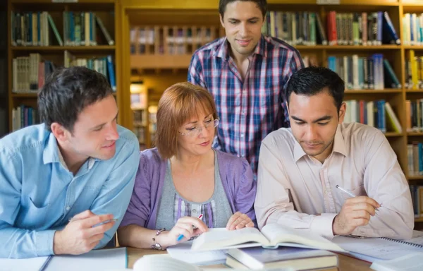 Estudantes adultos estudando juntos na biblioteca — Fotografia de Stock