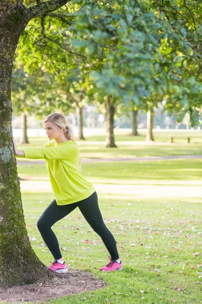 Passa ganska blond stretching benen — Stockfoto