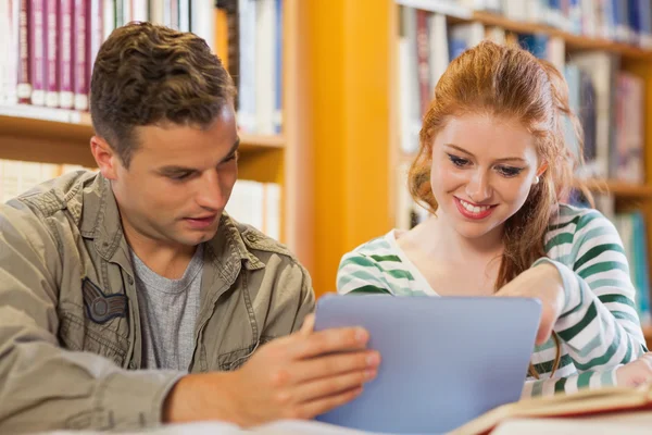 Two cheerful students studying together using tablet Stock Image