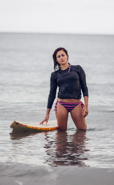 Portrait of a beautiful woman with surfboard in water — Stock Photo, Image