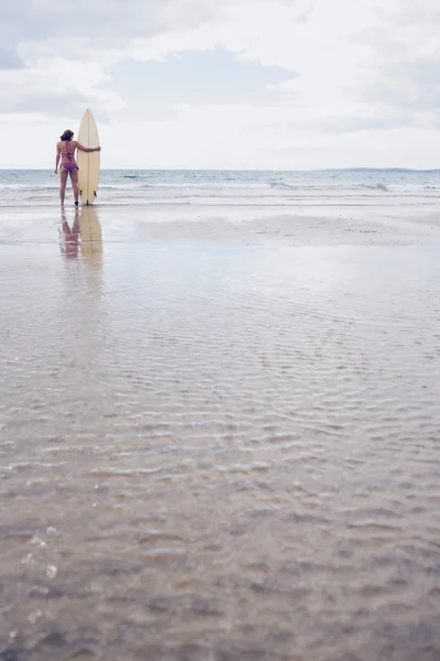 坦然的女人在比基尼在海滩上的冲浪板 — 图库照片
