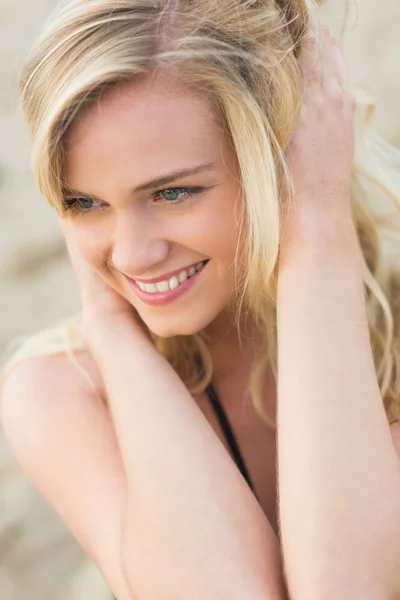 Улыбаясь, юная блондинка смотрит в сторону пляжа — стоковое фото