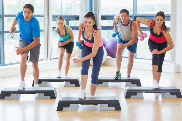 Trainer mit Fitnesskurs führt Step-Aerobic-Übungen mit Kurzhanteln durch — Stockfoto