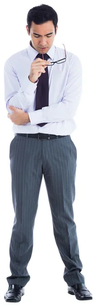 Unsmiling businessman holding glasses — Stock Photo, Image