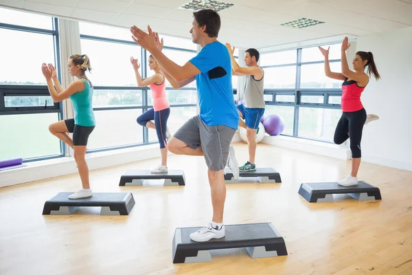 Instructor con clase de fitness realizando ejercicios aeróbicos paso a paso — Foto de Stock