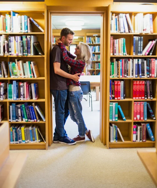 Studenti in piedi accanto alla libreria in biblioteca — Foto Stock