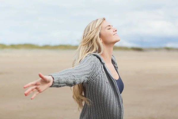 Seitenansicht einer Frau, die ihre Arme am Strand ausstreckt — Stockfoto