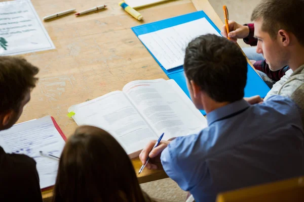 Estudantes escrevendo notas na biblioteca da faculdade — Fotografia de Stock