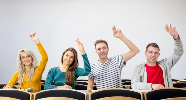 Estudiantes universitarios levantando las manos en el aula — Foto de Stock