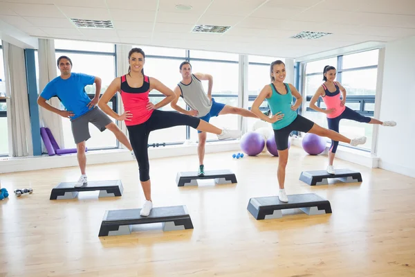 Istruttore con classe di fitness che esegue esercizi di step aerobica — Foto Stock