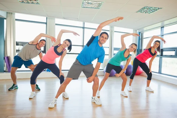 Gente sonriente haciendo ejercicio de fitness en clase de yoga — Foto de Stock