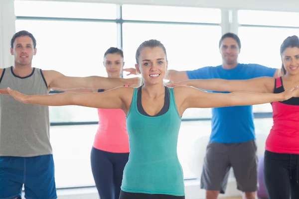 Portrait of sporty people stretching out hands at yoga class — Stock Photo, Image