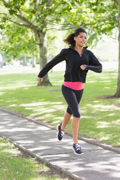 Mujer joven y saludable trotando en el camino en el parque — Foto de Stock