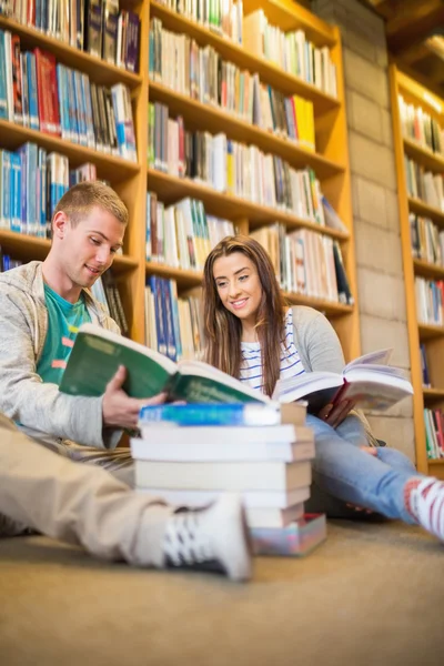 Studenti čtení knih na podlaze knihovny — Stock fotografie