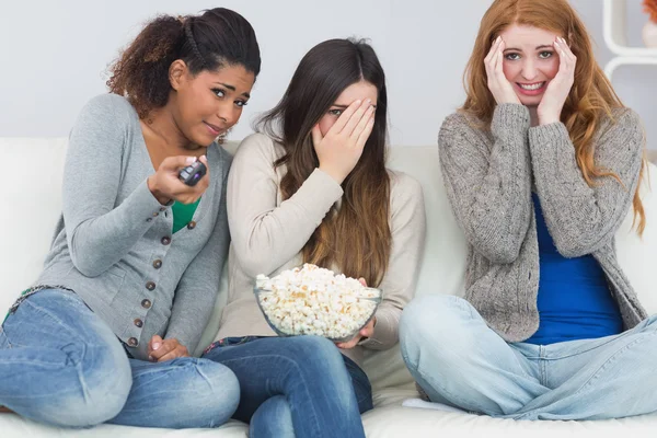 Bang vrienden met afstandsbediening en popcorn kom op sofa — Stockfoto