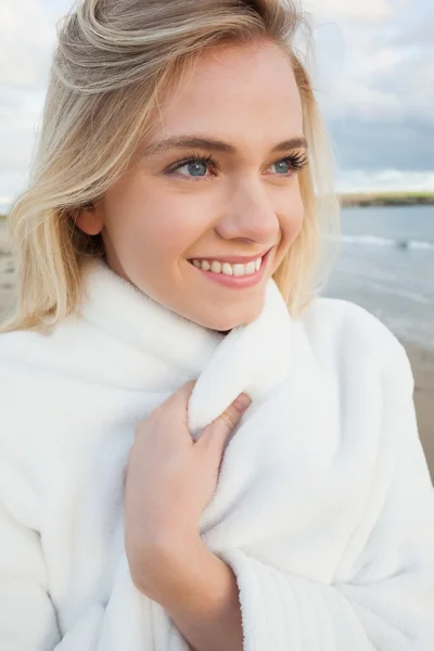 Mulher sorridente bonito na jaqueta branca elegante na praia — Fotografia de Stock