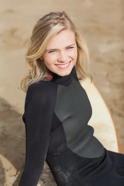 Porträt einer schönen Blondine im Neoprenanzug mit Surfbrett — Stockfoto