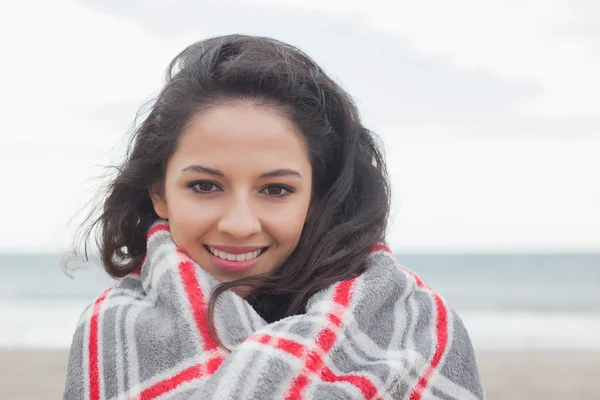 Young woman covered with blanket at beach — Stock Photo, Image