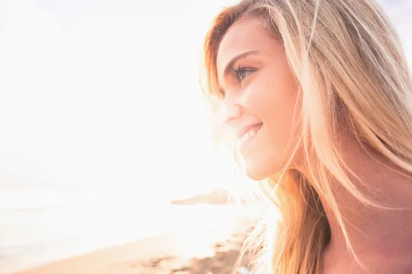 Close up de uma loira sorridente olhando para a praia — Fotografia de Stock