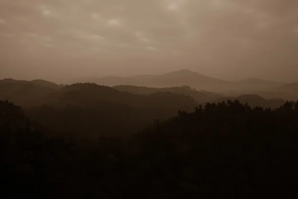 Arbres et chaîne de montagnes contre les nuages — Photo