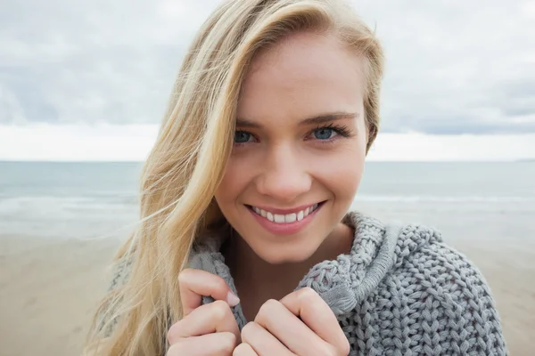 Carina donna sorridente in giacca grigia a maglia sulla spiaggia — Foto Stock