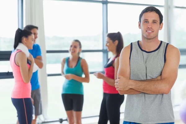 Instructor con clase de fitness en segundo plano en el gimnasio — Foto de Stock