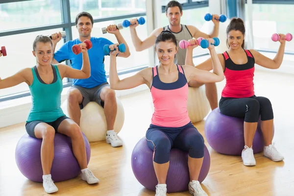 Gente haciendo ejercicio con pesas en las bolas de fitness —  Fotos de Stock