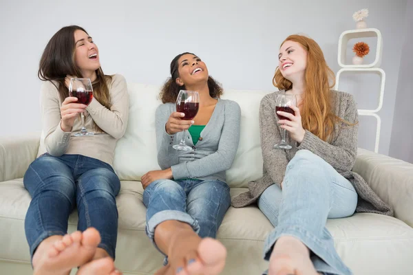 Jovens amigas alegres com copos de vinho em casa — Fotografia de Stock
