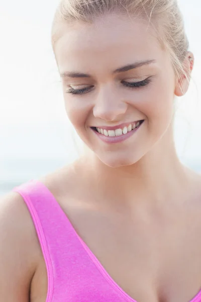 Närbild av en leende frisk kvinna som tittar ner — Stockfoto