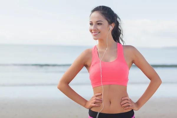 Beautiful smiling healthy with earphones on beach — Stock Photo, Image