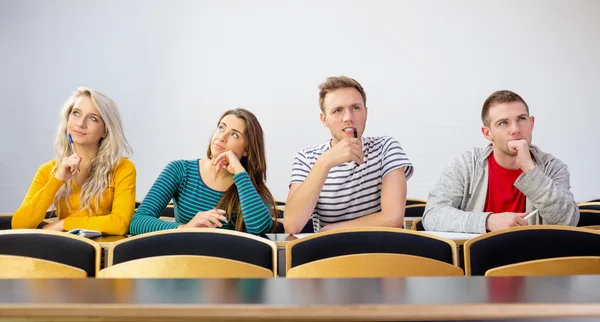 Thoughtful smiling college students in classroom — Stock Photo, Image