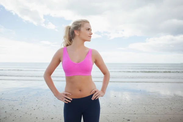 Afgezwakt vrouw met handen op de heupen op strand — Stockfoto