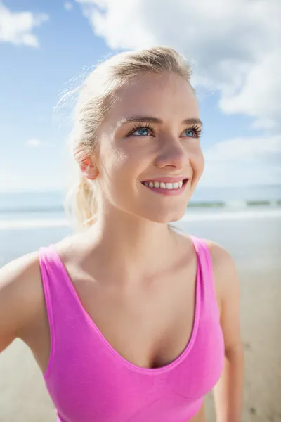 Sonriente mujer sana en rosa sujetador deportivo en la playa —  Fotos de Stock