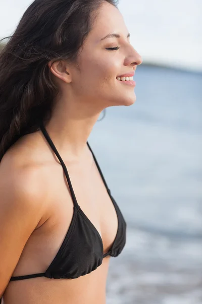 Vista lateral de una linda mujer con los ojos cerrados en la playa —  Fotos de Stock