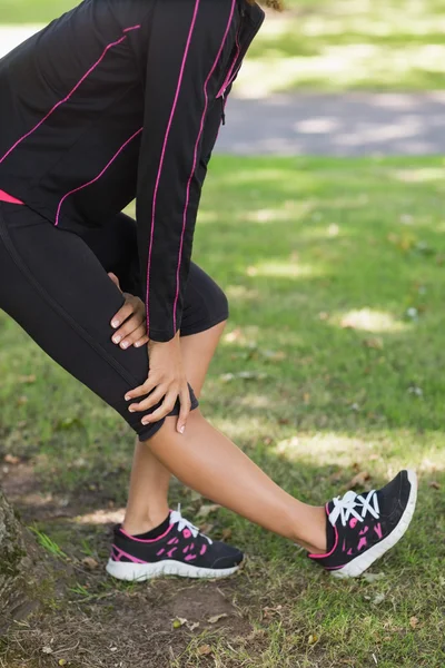 Sección media de la mujer estirando la pierna durante el ejercicio en el parque —  Fotos de Stock