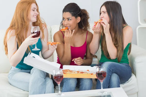 Felices amigas comiendo pizza con vino en casa —  Fotos de Stock