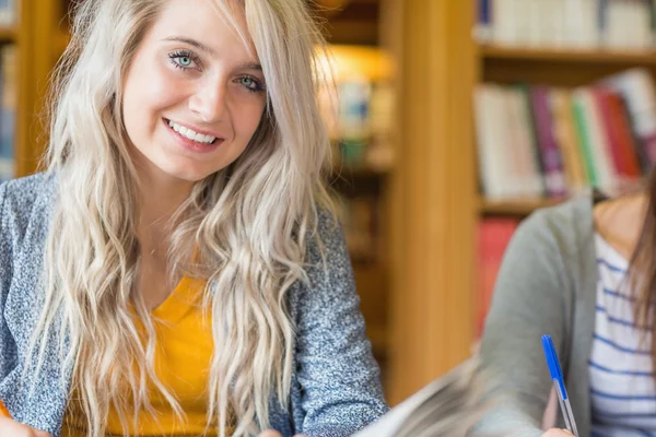 Portrait of a smiling female student at library — Stock Photo, Image