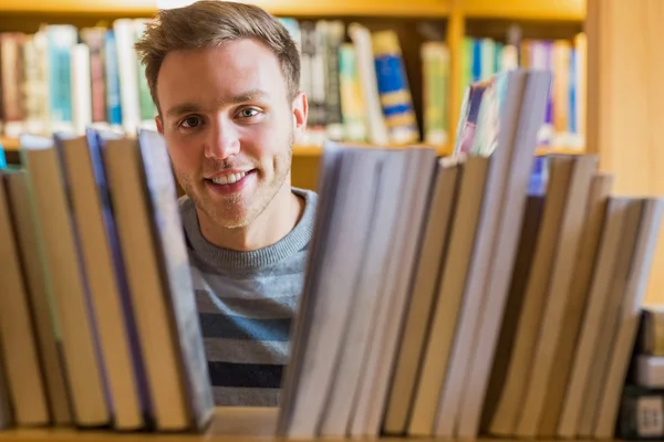 Manlig student att välja bok i biblioteket — Stockfoto