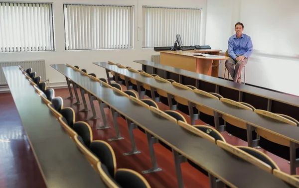 Елегантний вчитель чоловічої статі сидить у лекційній залі — стокове фото