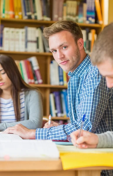 Ler manlig student med vänner på biblioteket skrivbord — Stockfoto