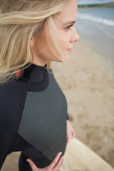 Zijaanzicht van prachtige blond in nat pak op strand — Stockfoto