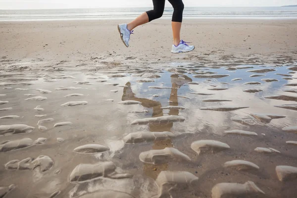 Geringen Teil eine gesunde Frau, Joggen am Strand一个健康的女人，在海滩上慢跑的低段 — 图库照片