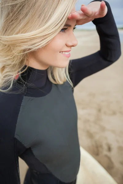 해변에서 눈을 보호 하는 아름 다운 금발 머리의 측면 보기 — 스톡 사진