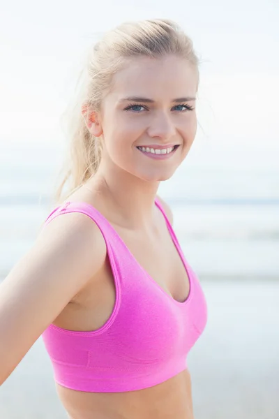 Close up of healthy woman in pink sports bra on beach — Stock Photo, Image