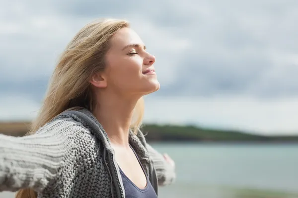 Vista lateral de la joven mujer estirando los brazos en la playa —  Fotos de Stock