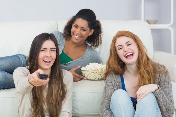 Fröhliche Freunde mit Fernbedienung und Popcornschale zu Hause — Stockfoto