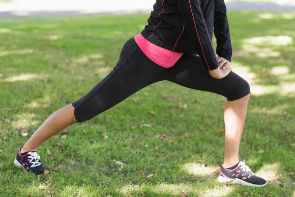 Låga delen av kvinna gör stretching övning i park — Stockfoto