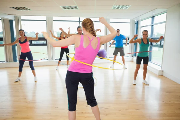 Aula de fitness e instrutor balançando aros hula na cintura — Fotografia de Stock