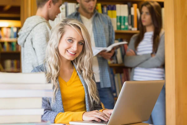 Zadowoleni uczniowie komputera przenośnego na biurku w bibliotece — Zdjęcie stockowe