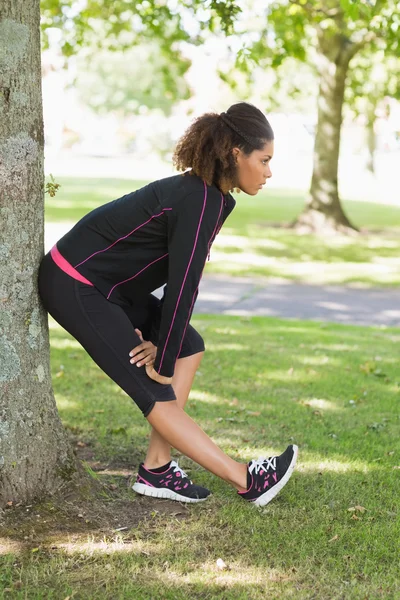 Gesunde Frau streckt ihr Bein bei Sport im Park — Stockfoto